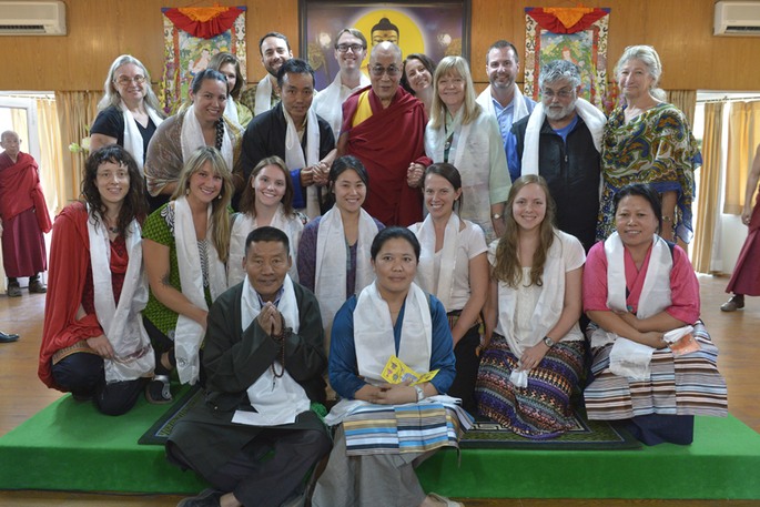 The Dalai Lama poses for a photo with a group of students and staff