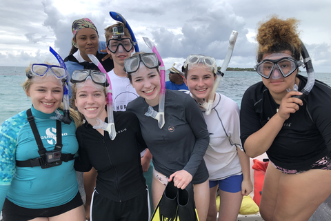 A group of students pose for a photo mid-snorkel in Belize