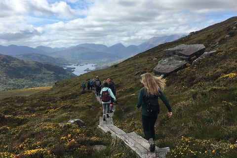 A group of students walk through rolling hills and valleys on a hike in Limerick, Ireland